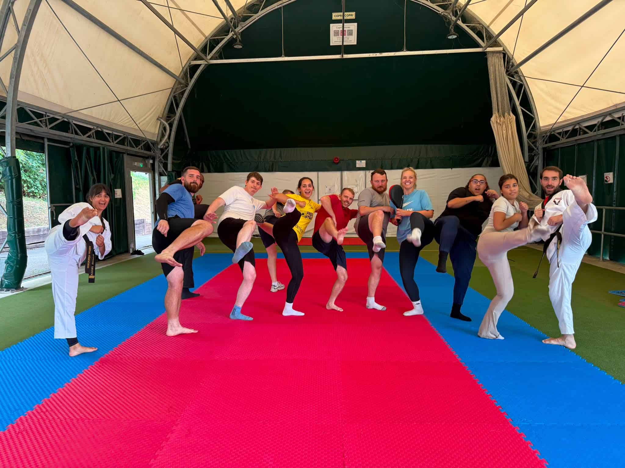 Group of young people practicing martial arts in a training tent.