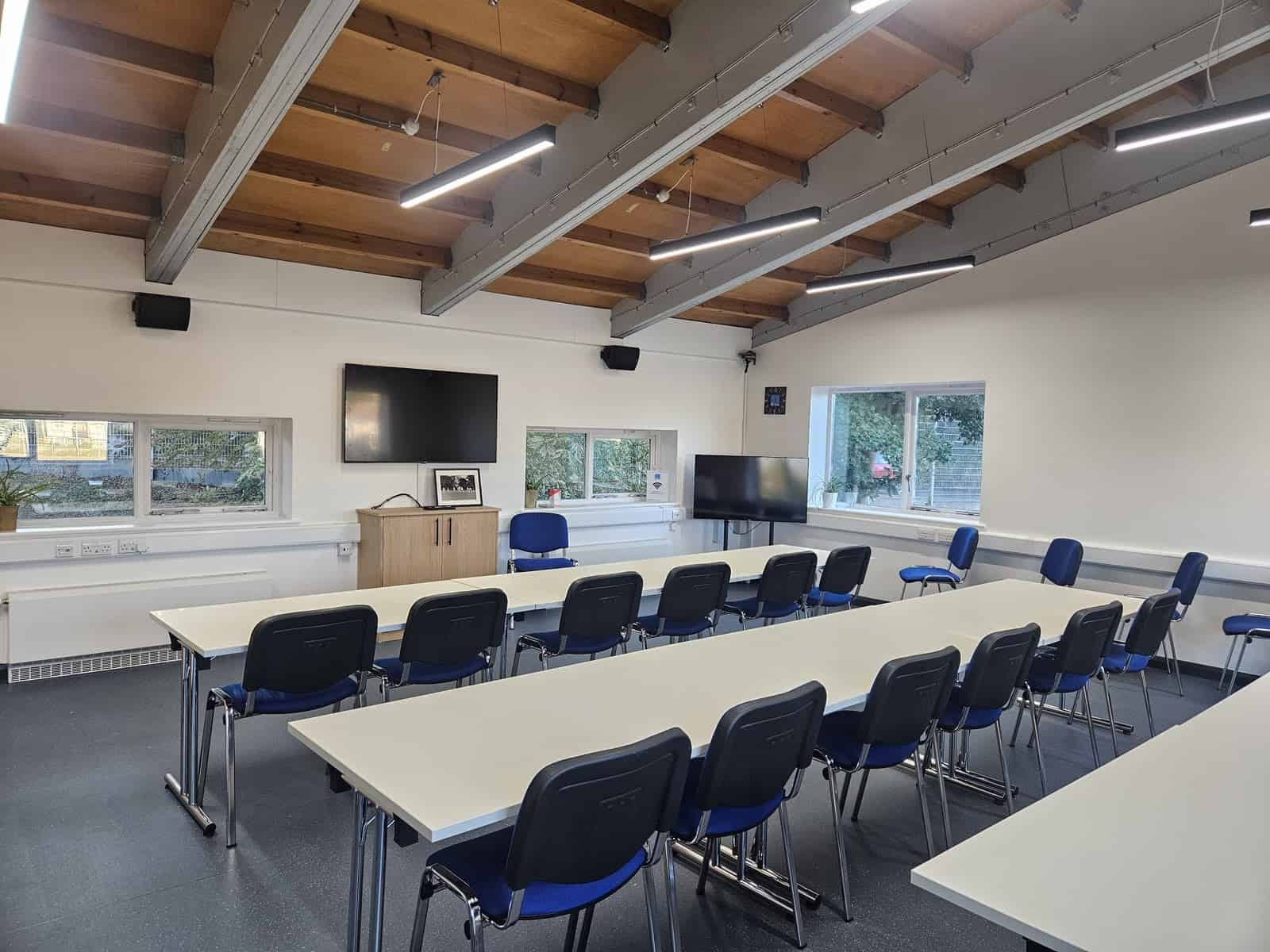 Bright training room with tables, chairs, and screens at The Change Foundation.